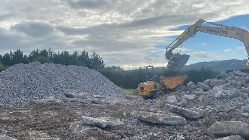 Komatsu excavator loading crushed stone into a site dumper