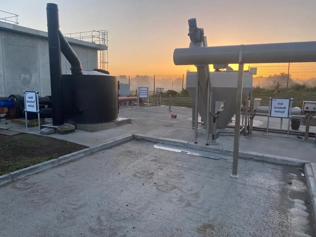 Wastewater treatment plant at sunrise showing odour and grit-removal systems